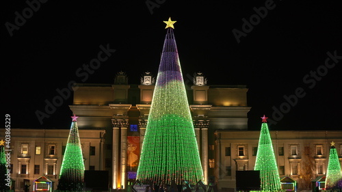 Evening Russia, Samara, Kuibyshev Square, five Christmas trees fully decorated with bulbs glow with different patterns photo