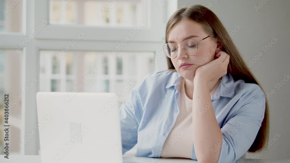 Sleepy woman in eyeglasses trying to concentrate on work sitting at home office Sleepy woman in eyeglasses trying to concentrate on work sitting at home office