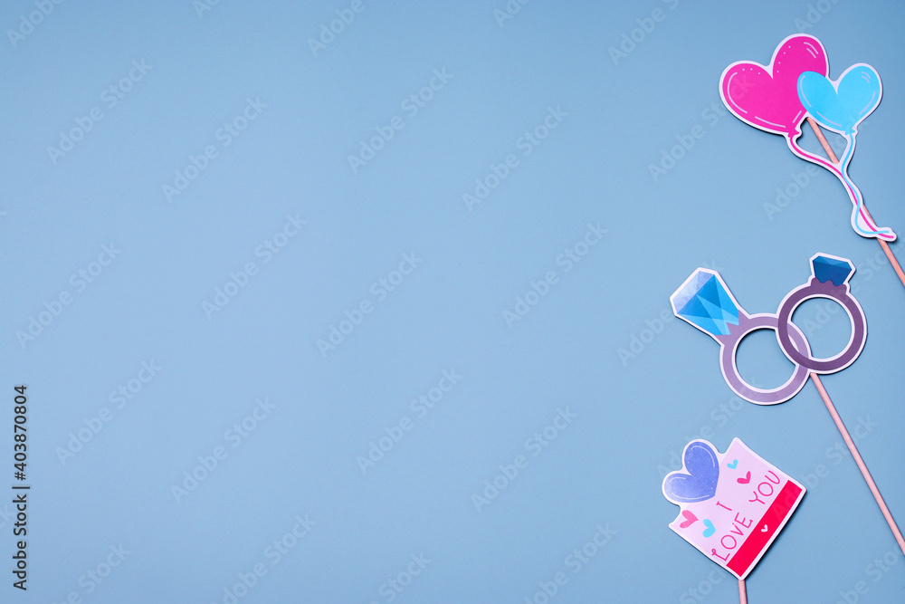 Postcard concept for Valentines, Womens Day, Mothers Day, Birthday, Mens Day, Wedding Day. Party accessories on a blue background. Flat lay, top view. Copy space. Postcard concept for Valentines, Womens Day, Mothers Day, Birthday, Mens Day, Wedding Day. Party accessories on a blue background. Flat lay, top view. Copy space.