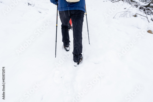Rear view of Man walking through the deep snow on a winter day, motion blur defocus