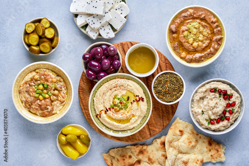 Middle eastern, arabic traditional breakfast with hummus, foul, mutabbal, qudsia and zaatar. Top view photo