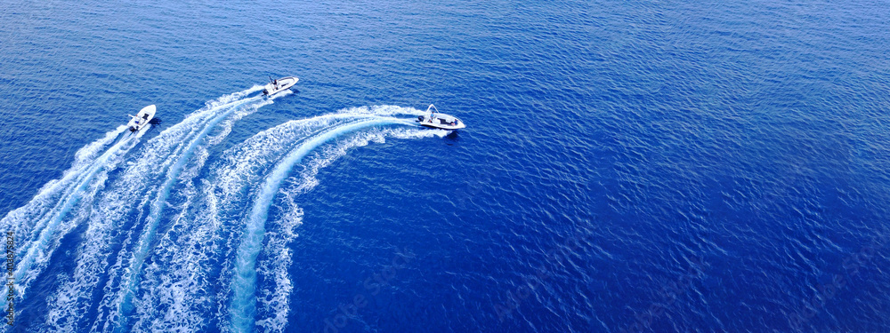 Aerial drone ultra wide top down photo of synchronised powerboats cruising in high speed in deep blue open ocean sea - obrazy, fototapety, plakaty 