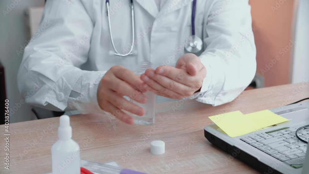 A man treats his hands with an antiseptic while sitting at the table. Health concept. A man treats his hands with an antiseptic while sitting at the table. Health concept.