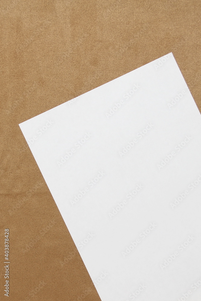Template of white paper lies diagonally on light brown cloth background. Concept of business plan and strategy. Stock photo with empty space for text and design. Template of white paper lies diagonally on light brown cloth background. Concept of business plan and strategy. Stock photo with empty space for text and design.