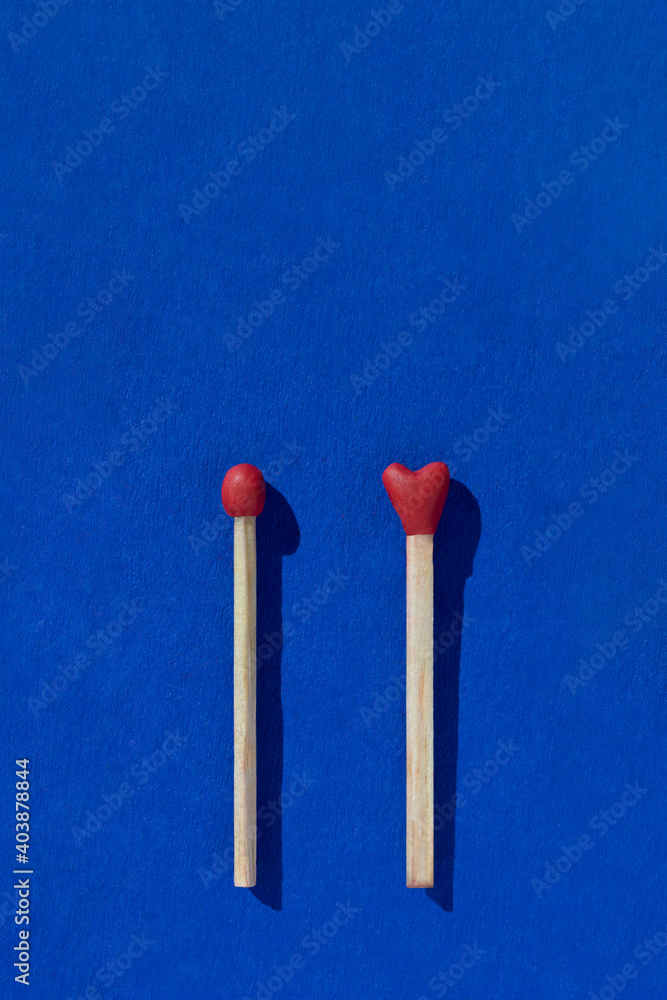 Two heart shaped red matchsticks couple, blue background. Сoncept of perfect match, fire of love and passion. The one and only. Happy Valentines Day. Holiday romantic wedding poster, greeting card. Two heart shaped red matchsticks couple, blue background. Сoncept of perfect match, fire of love and passion. The one and only. Happy Valentines Day. Holiday romantic wedding poster, greeting card.