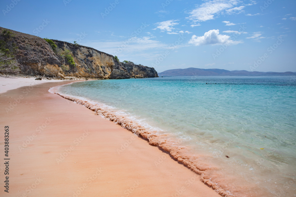 soft waves crashing on the remote pink beach in Komodo National Park in Indonesia