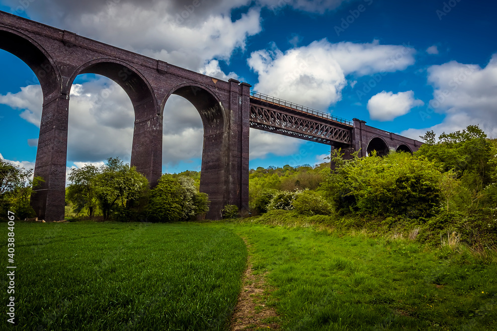 A path leads underneath the Conisbrough Viaduct as it crosses over the River Don at Conisbrough, Yorkshire, UK in springtime