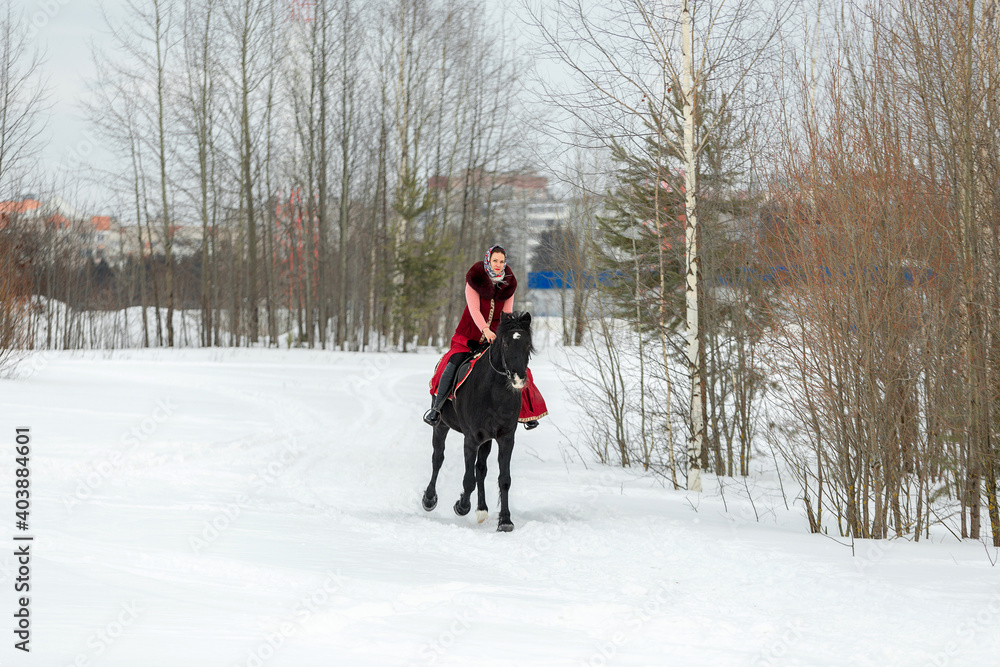 Young woman on horseback riding outdoors in winter