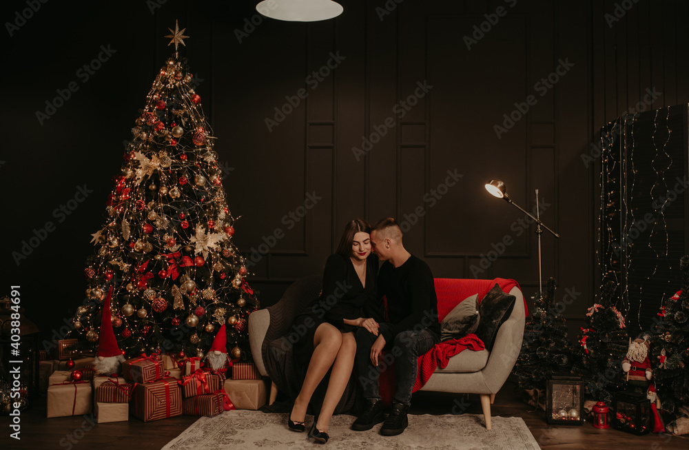 love couple man and woman hugging kissing near Christmas tree.