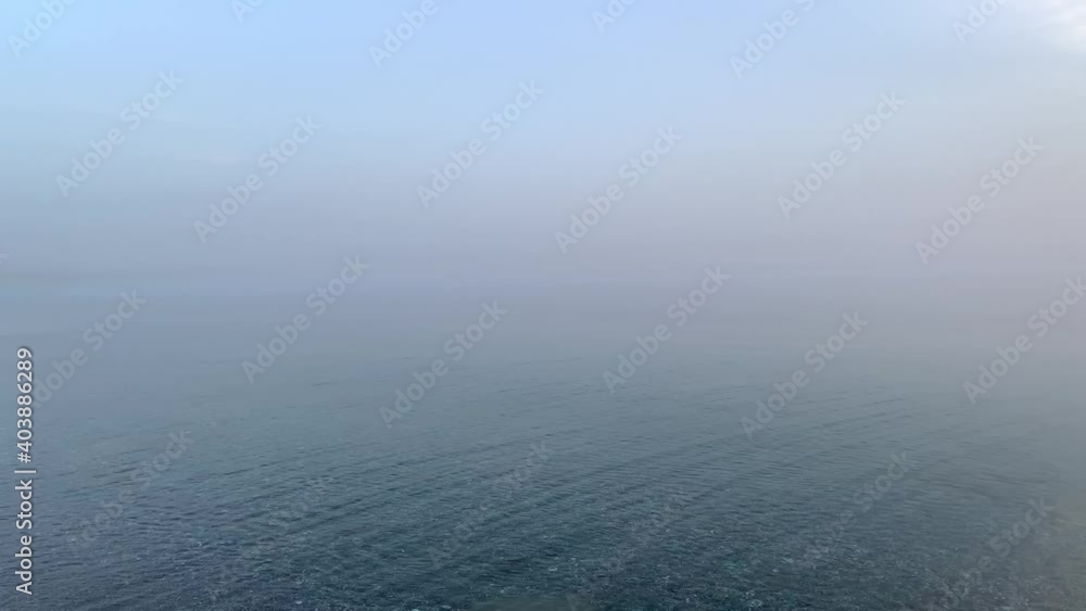 foggy sunset over the calm sea foggy sunset over the calm sea