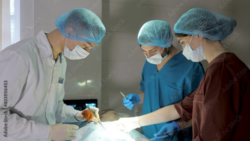 Surgeons are operating. Resuscitation medicine team wearing masks holding medical tools Surgeons are operating. Resuscitation medicine team wearing masks holding medical tools