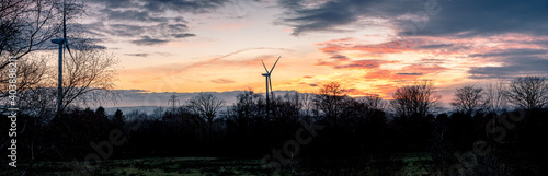 View of wind turbines during golden hour sunset in south wales uk pen y fan pond. energy concept.