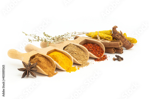 Various spices in spoon isolated on white background, cinnamon, turmeric, caraway, pepper flakes, galangal, anise, thyme