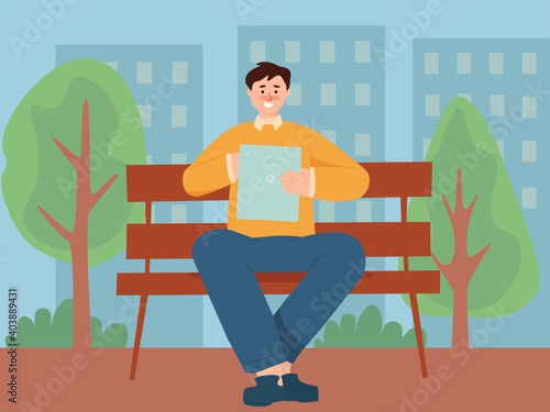 A man using tablet computer in a park 