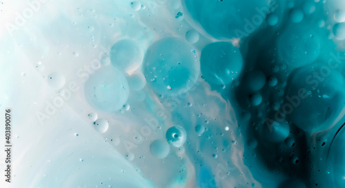 beautiful background of paint bubbles floating on water with mix of oil blue