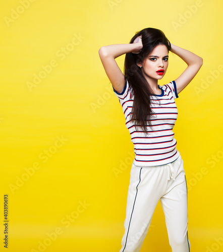 lifestyle people concept: pretty young school teenage girl having fun happy smiling on yellow background