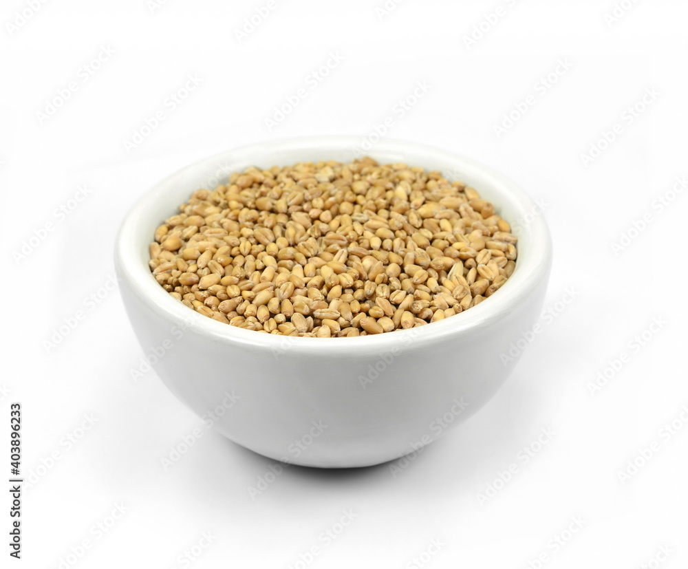 wheat grains in white bowl isolated on white background. wheat grains in white bowl isolated on white background.