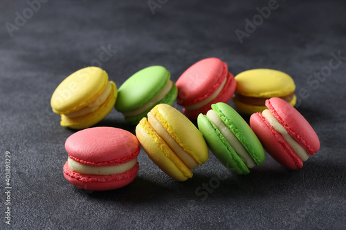 Colorful french macaroons on dark grey background. Closeup. Horizontal format