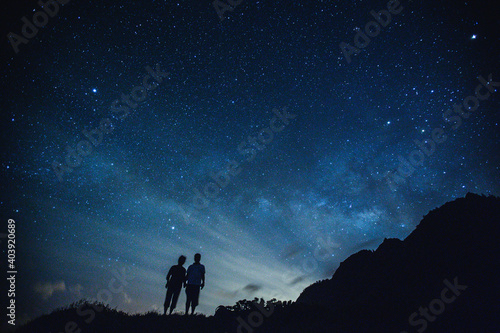 Silhouette of elderly couple on the hill.  Stargazing at Oahu island  Hawaii. Starry night sky  Milky Way galaxy astrophotography.