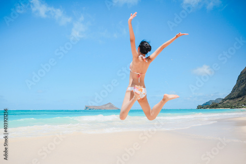 Girl jumping in Waimanalo Beach Park, Oahu, Hawaii