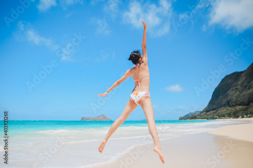 Girl jumping in Waimanalo Beach Park, Oahu, Hawaii