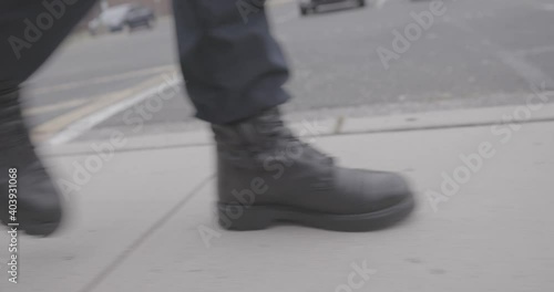 Police Officer Walking Down Parking Lot Sidewalk Ground Level 4K