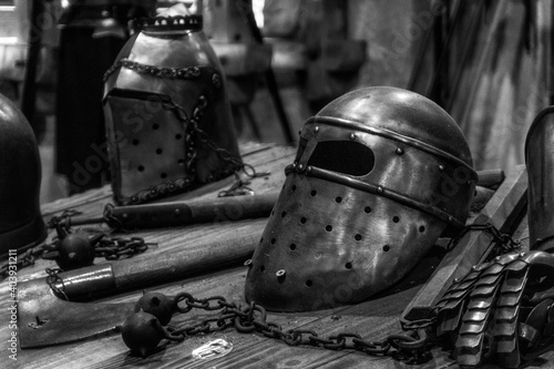 Metal helmet of medivial knight, ax and morning star on table photo