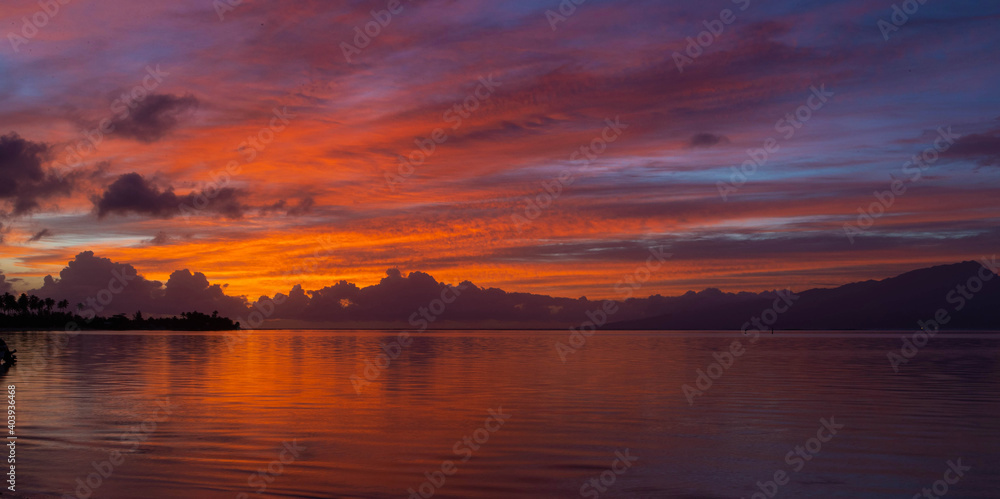Beautiful sunrise with colorful sky over the ocean in tropical French Polynesia