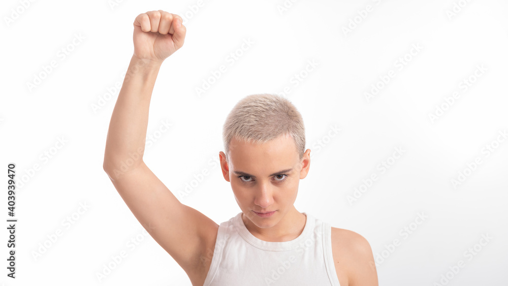 Young caucasian woman holding her fist up on a white background. A girl with short hair is fighting for rights Young caucasian woman holding her fist up on a white background. A girl with short hair is fighting for rights
