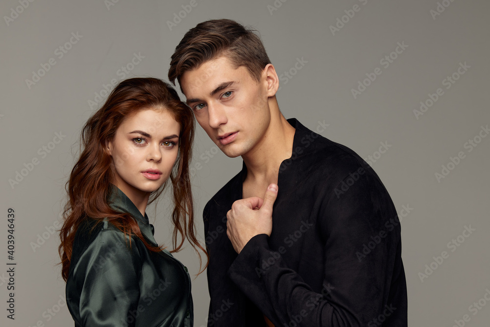 romantic man and woman in suits on gray background looking forward romantic man and woman in suits on gray background looking forward