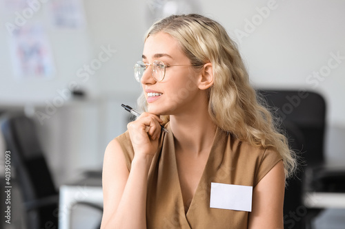 Young woman with blank badg...