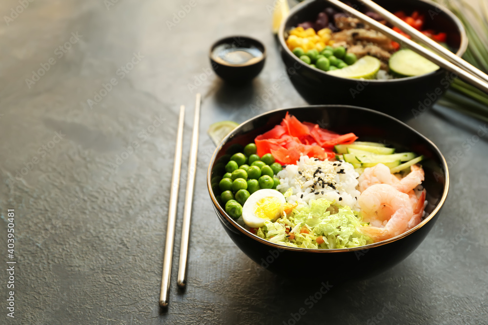 Bowls with tasty rice, shrimps and vegetables on dark background Bowls with tasty rice, shrimps and vegetables on dark background