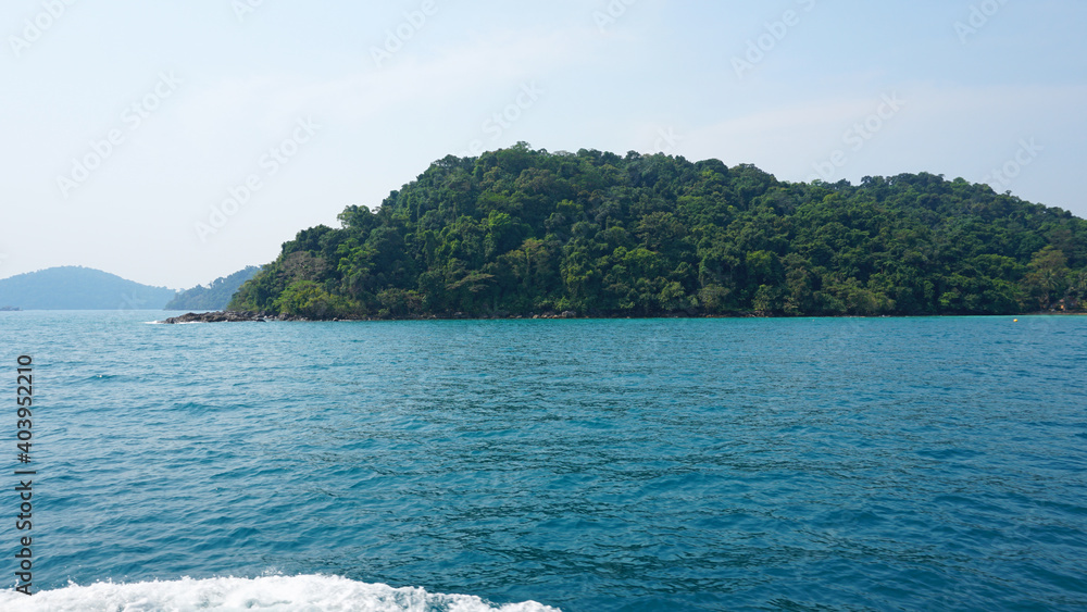 Travel by sea in Thailand by ship. View of the open ocean, green Islands and gray sky in smog. Green water with waves. Sailing between the Islands. Ship from different sides: stern, bow, rope, anchor. Travel by sea in Thailand by ship. View of the open ocean, green Islands and gray sky in smog. Green water with waves. Sailing between the Islands. Ship from different sides: stern, bow, rope, anchor.