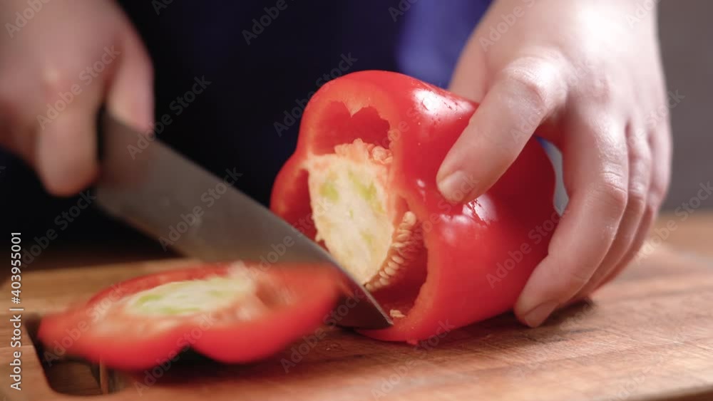 Close-up shot of a culinary master slicing red bell pepper for cooking as a culinary ingredient in a restaurant kitchen Close-up shot of a culinary master slicing red bell pepper for cooking as a culinary ingredient in a restaurant kitchen