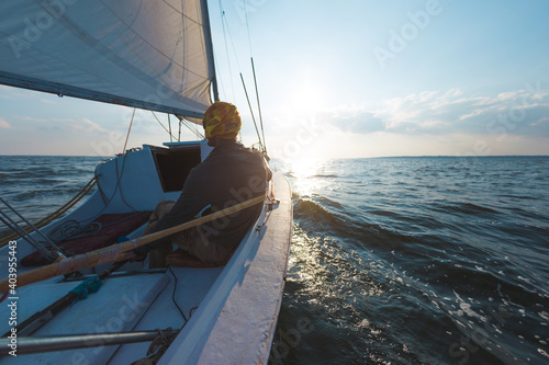 A man on a sailing yacht at sunset  a solo boat trip