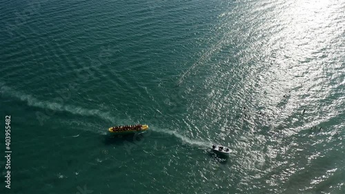 inflatable banana with tourists returns to the shore after a walk.