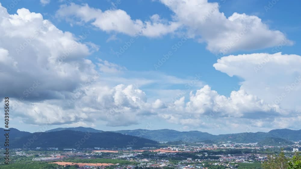 White Clouds move in the Clear blue Sky over Buildings in Phuket City. Motion Time lapse White clouds swim and change shape.Puffy fluffy soft clouds,Cloudscape timelapse over mountain Summer season