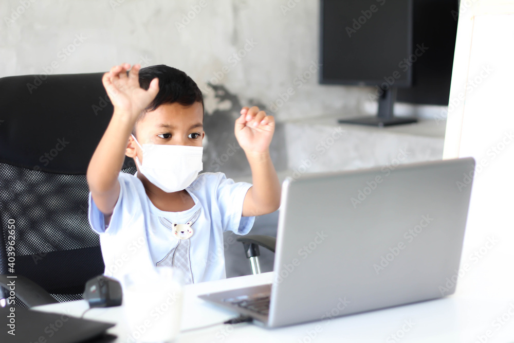 Asian boy kid sitting at table with laptop and preparing to school. Online education concept. Online video call conference class lesson study. Asian boy kid sitting at table with laptop and preparing to school. Online education concept. Online video call conference class lesson study.
