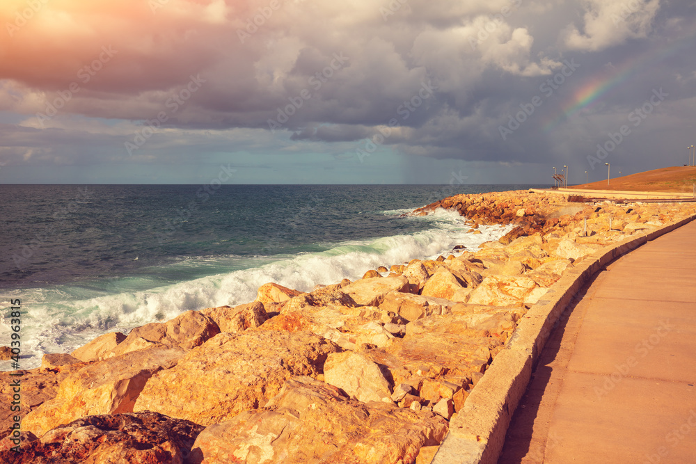 Seascape with a dramatic cloudy sky, rocky seashore. The embankment in Tel Aviv-Yafo, Israel. Harry Truman str.