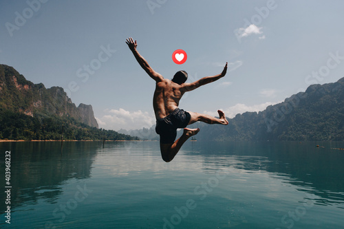 Adventurous man jumping into a lake photo