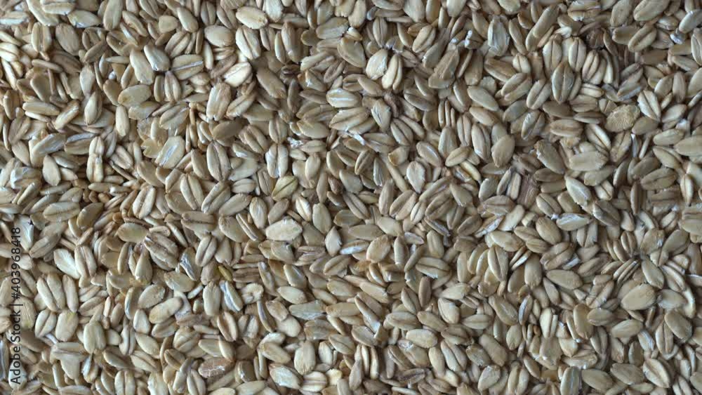 Oat flakes rotating. Oatmeal, close up, top view. Dry oat flakes grains background. Food background. Gastronomy concept, organic food Oat flakes rotating. Oatmeal, close up, top view. Dry oat flakes grains background. Food background. Gastronomy concept, organic food