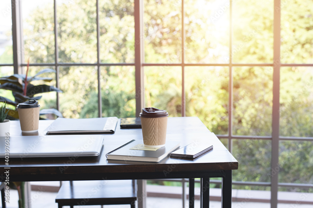 coffee in paper cup ,Laptop and notebook on wooden table in office coffee in paper cup ,Laptop and notebook on wooden table in office