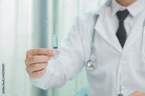 Doctor in mask taking vaccine with syringe
