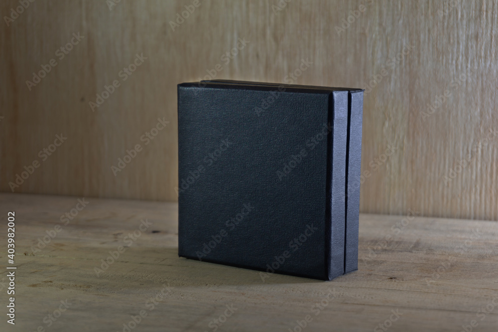 close up of a black box template on wood background, mock up design close up of a black box template on wood background, mock up design