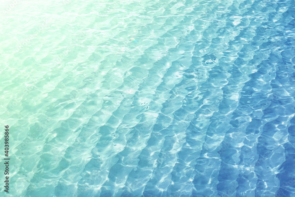 Light ripples on water ocean. Beautiful texture of light waves in blue turquoise transparent sea water, summer background. Light ripples on water ocean. Beautiful texture of light waves in blue turquoise transparent sea water, summer background.