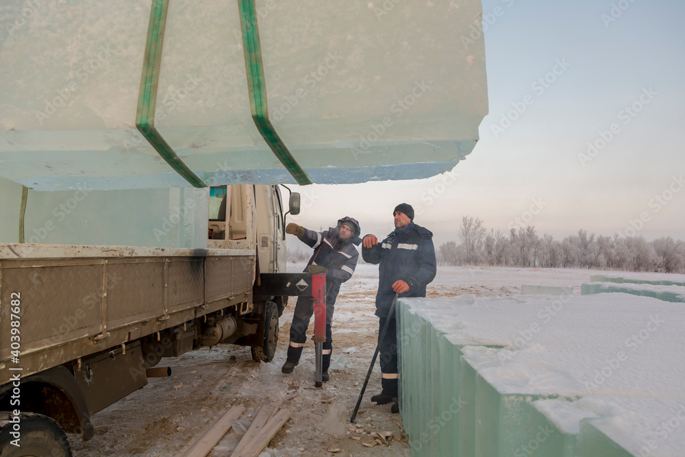 Workers load ice blocks from a car Workers load ice blocks from a car