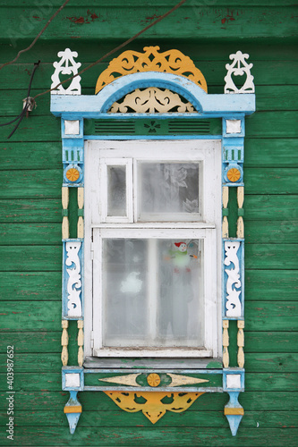 Ornamental window with carved frame on vintage wooden rural house in Nerekhta town, Kostroma region, Russia. Building facade. Russian traditional national folk style in architecture. Russan landmark photo