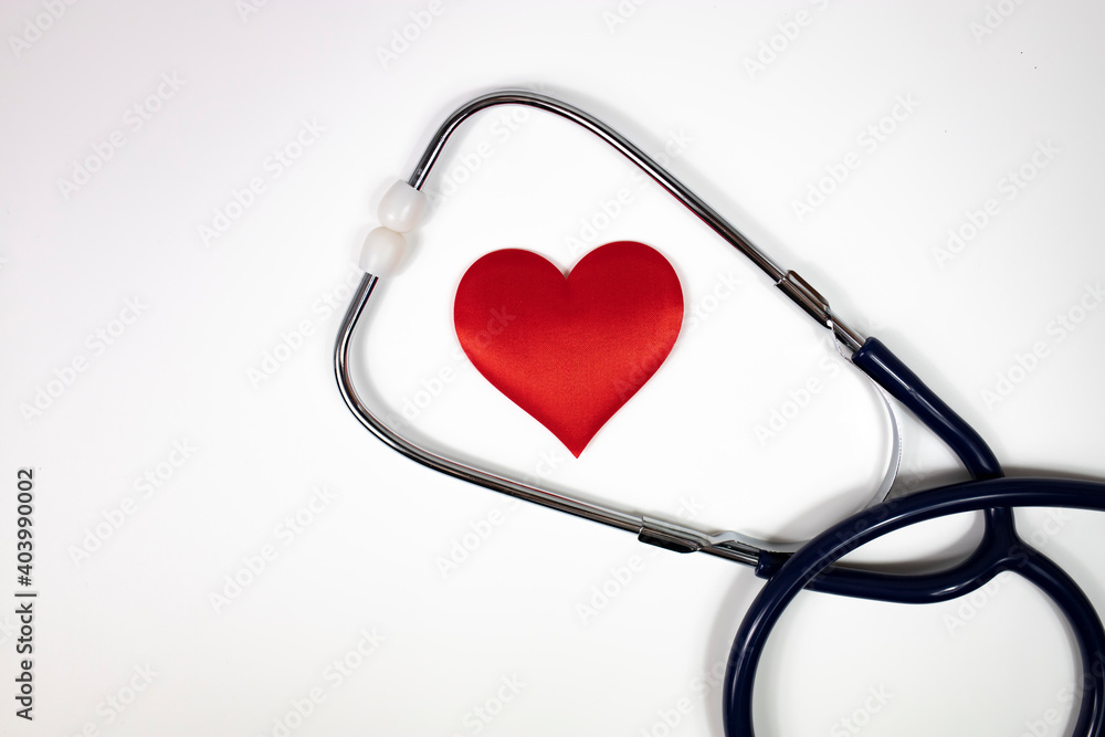 A stethoscope and a red heart on a white background. Top view. A stethoscope and a red heart on a white background. Top view.