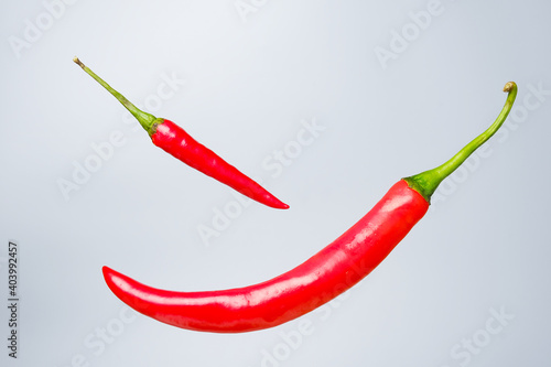 A levitation picture of the hottest chilli pepper and red chilli on gray background