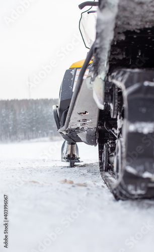 Rear suspension of a snowmobile in winter on snow  side view.